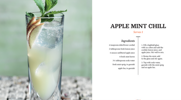The Art of Mixology: Mocktails - Tall clear glass filled with a pale yellow Apple Mint Chill mocktail, garnished with fresh green mint leaves and apple.