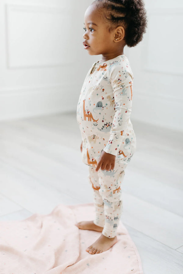  A little girl wearing the Baby Dinomite Sleeper by LouLou Lollipop