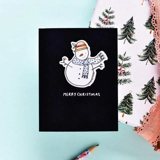 A black card with a white snowman in the center wearing a scarf and hat. Underneath reads 
