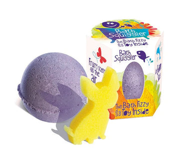 Bath Squiggler - Purple bath bomb with arrow detail and yellow bunny soap next to colorful Canadian handmade Bath Squiggler gift box.