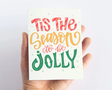 Tis the Season to Be Jolly Christmas Card - Handheld handmade Christmas card with red, gold, and green festive lettering, unique Canadian gift.