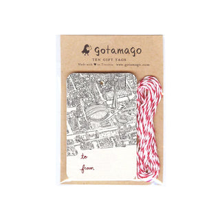 A white gift tag with a detailed fine line illustration of downtown Toronto including the CN tower, the Rogers Centre the surrounding buildings from a birds-eye view. Next to the gift tags is red and white twine.