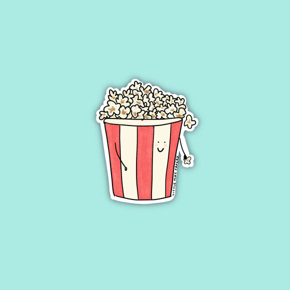 A red and white striped popcorn bucket filled with popcorn with a smiley face and stick arms