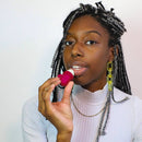 GIFT SET 3 Pack Lip Balm FALL EDITION - Woman applying pink lip balm from a unique handmade Canadian gift set, styled with braided hair and gold earrings.