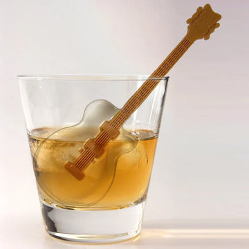 Cool Jazz Ice Stirrers Mold - Brown guitar-shaped ice stirrer in a whiskey glass with round ice, unique handmade Canadian gift.