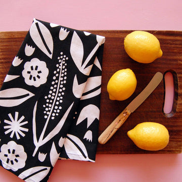 June Floral Tea Towel - Handmade Canadian tea towel with bold white floral print on black, styled with lemons and knife gift idea.