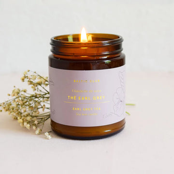 Earl Grey Tea Soy Candle - Amber glass jar candle with lilac label reading Earl Grey Tea, handmade Canadian gift with dried flowers.