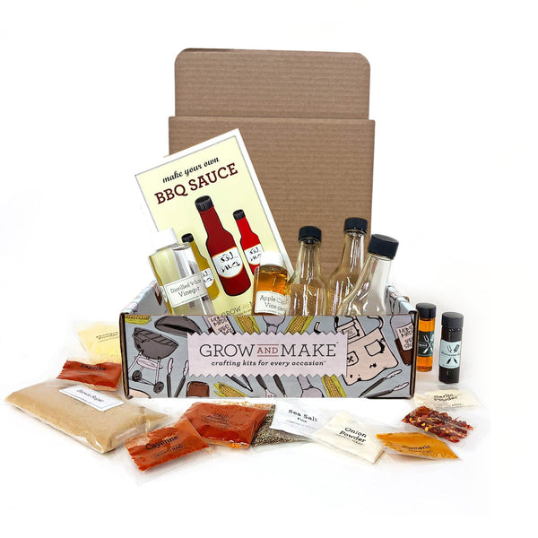 A cardboard box open to show it has bottles, instructions and ingredients inside. Seasoning packets surround the box