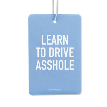 Learn to Drive Air Freshener - Blue rectangular air freshener with white bold text "Learn to Drive Asshole," unique handmade Canadian gift accessory.