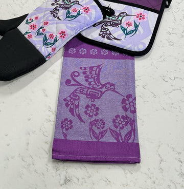 Printed Tea Towel - Hummingbird (purple) - Purple cotton tea towel with hummingbird and floral print folded on marble surface.