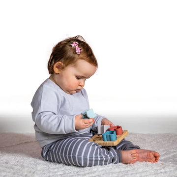 Simply Silicone Bamboo Sorter - 4x4" - Baby playing with a 4x4" bamboo sorter toy featuring pastel-colored silicone shapes.