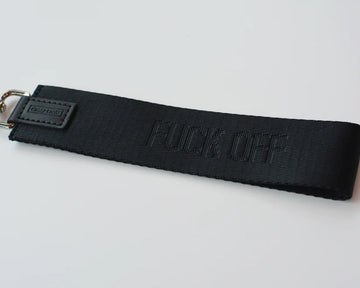 Fuck Off Wristlet - Black fabric wristlet with embossed "FUCK OFF" text and metal clip attachment.