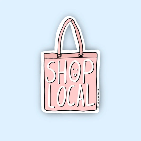 A sticker of a pink tote bag that says "Shop local" with the 'o' in shop as a smiley face