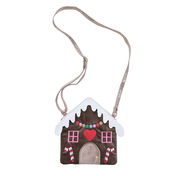 A brown cross-body bag shaped like a gingerbread house decorated with frosting, candy canes and a heart. The bag has a glitter strap