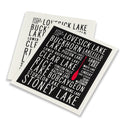 Dishcloth 1: black with white border and white text listing Kawartha lake names. Dishcloth 2: white with black text listing same Kawartha lake names. Both have a red canoe oar on them.