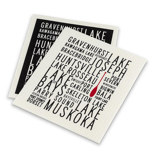 Dishcloth 1: black with white border and white text listing Muskoka lake names. Dishcloth 2: white with black text listing same Muskoka lake names. Both have a red canoe oar on them.