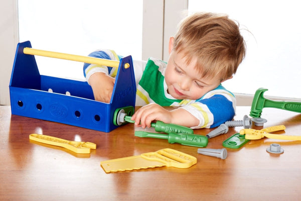 boy playing with Toy blue Tool Set (Green Toys) with toolbox screwdriver saw hammer wrench for children