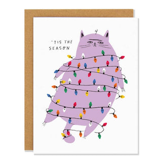 Christmas card with a cat wrapped in Christmas lights with the phrase 'Tis the Season on the top left corner 