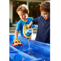 children playing with tugboat in water (Green Toys)