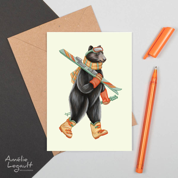 A white card with a black bear wearing skiiing equipment and holding skis