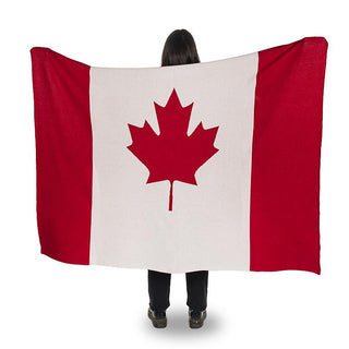 Person holding throw with Canadian flag on it (outer thirds red with white middle and red maple leaf).