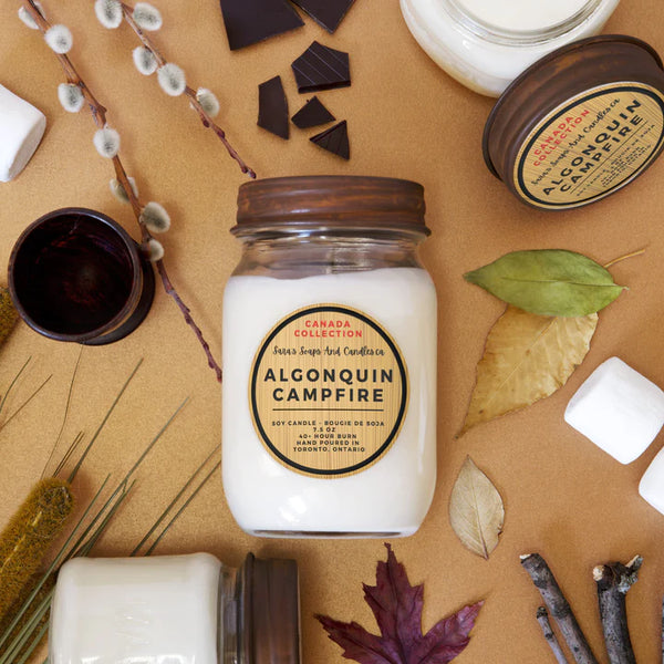 A 14oz candle in a clear jar with brown rustic lid and brown sticker with the name of the scent in the middle