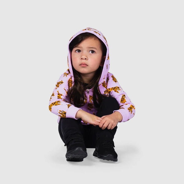 Child sitting, wearing purple hoodie with orange tigers throughout