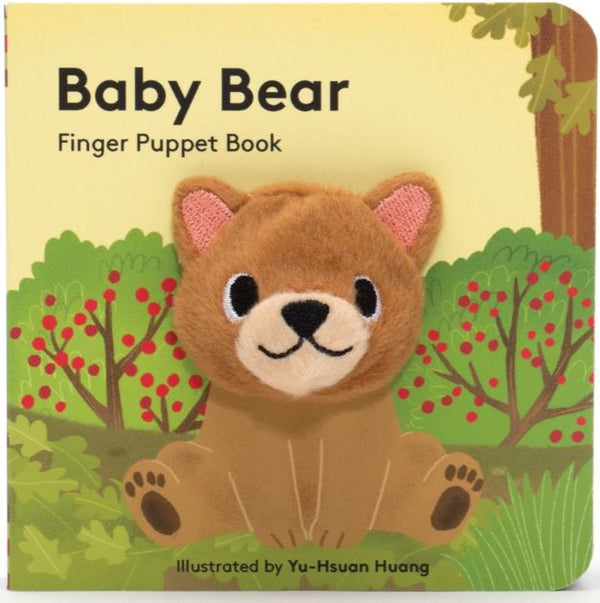 A book with a bear sitting in a forest. The head of the bear is a finger puppet