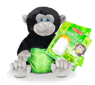 A baby gorilla stuffed animal wearing a green diaper while holding a white baby bottle