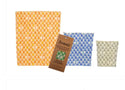 3 beeswax bags lined up from largest to smallest. The largest is yellow, the second largest is blue and the smallest bag is green-beige