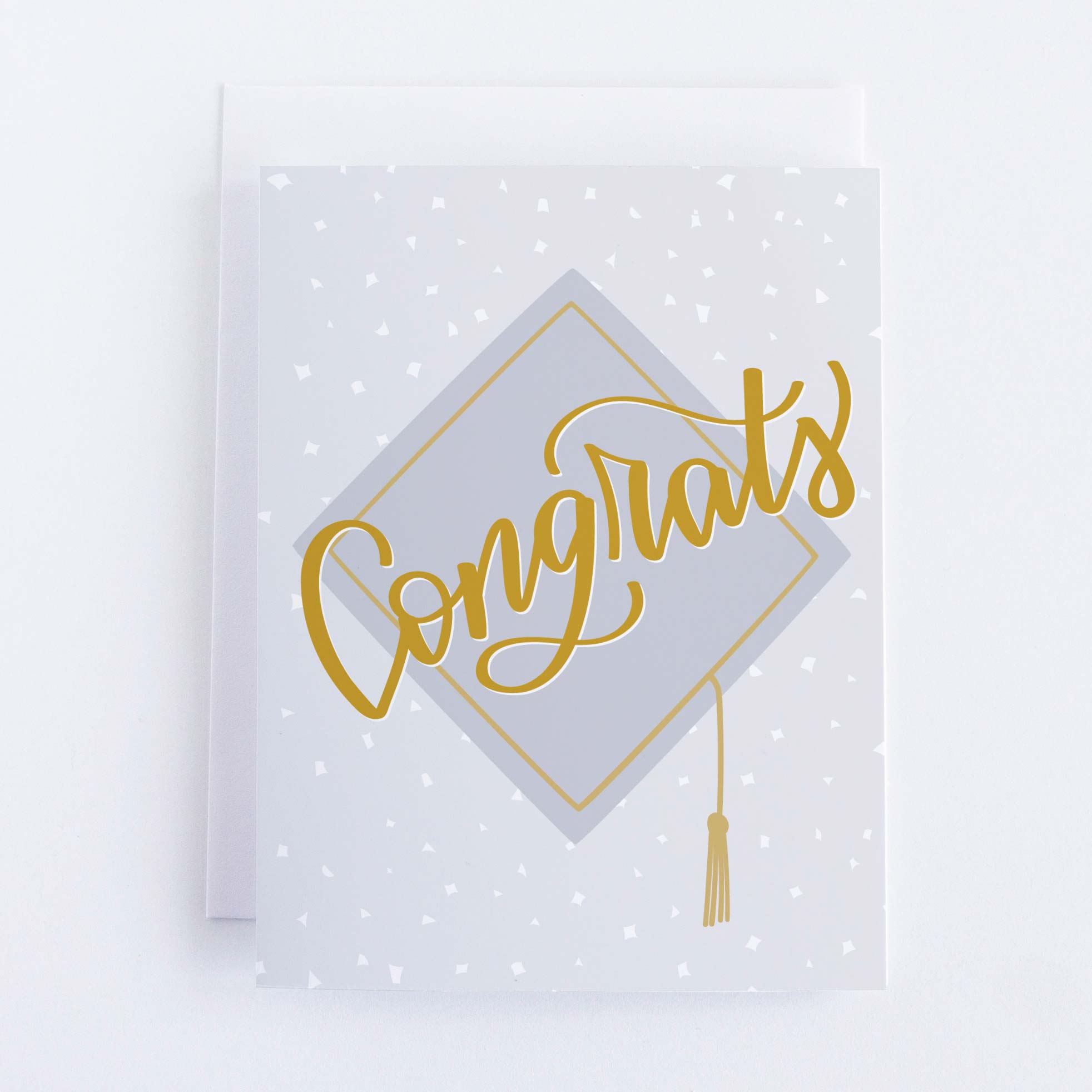 A polka dot card with a picture of a grad cap and the words “Congrats”