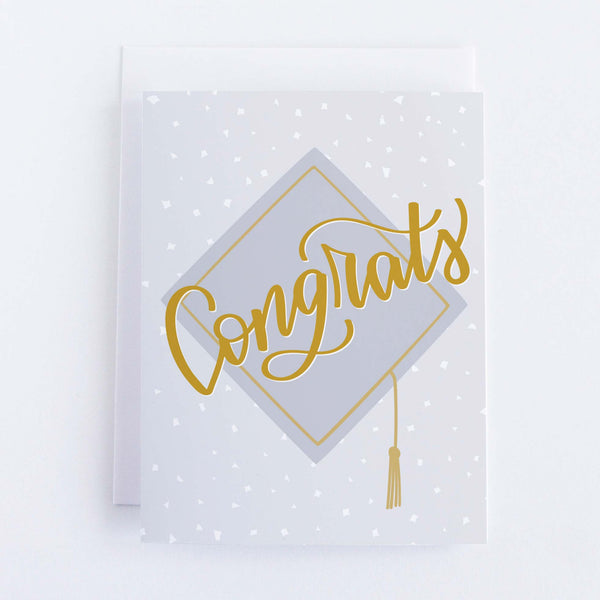 A polka dot card with a picture of a grad cap and the words “Congrats”