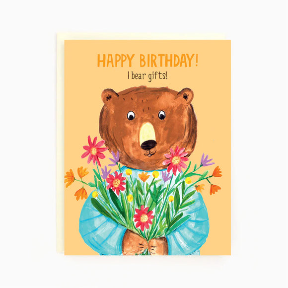 A light orange card with a picture of a brown bear holding different colored flowers and the words "Happy Birthday! I bear gifts"