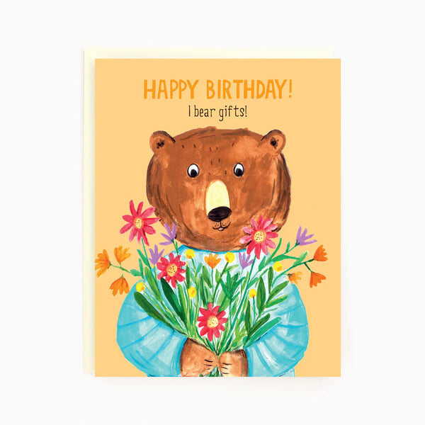 A light orange card with a picture of a brown bear holding different colored flowers and the words 