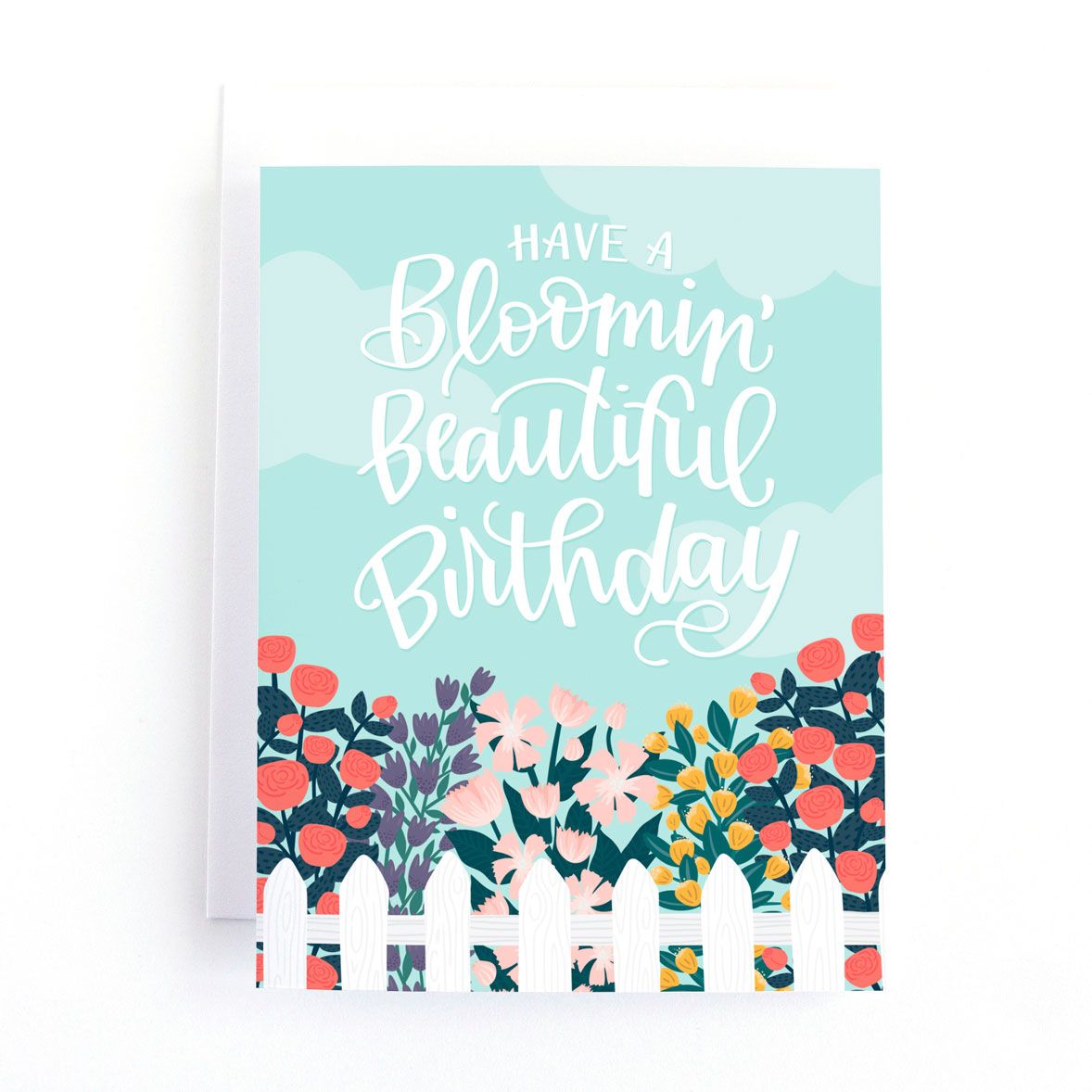 A blue card with flowers and a fence and the words "Have a Bloomin' Beautiful Birthday"