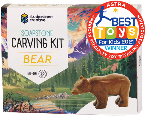A box with a picture of a brown bear statue in front of an illustrated lake and forest. In the top right corner is a red stamp reading "ASTRA Best toys for kids 2021 winner"