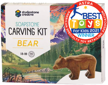 A box with a picture of a brown bear statue in front of an illustrated lake and forest. In the top right corner is a red stamp reading "ASTRA Best toys for kids 2021 winner"