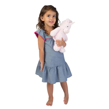 A girl wearing blue holding the pink unicorn plushy 