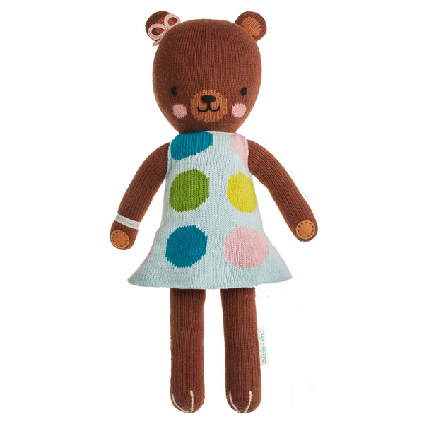 A brown bear stuffy wearing a polka dot dress