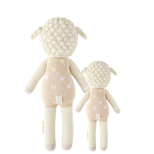  2 different sized lamb stuffies, both in pink polka dot overalls