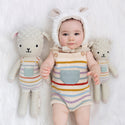 The 2 different sized dolls on either side of a baby wearing the matching overalls and lamb ears