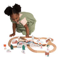 A little girl playing with the train track