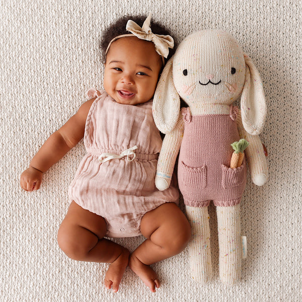 A big bunny stuffy beside a baby