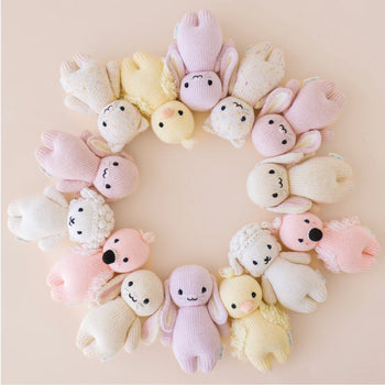 cuddle + kind Baby Animals - Circle of pastel-colored handmade baby animal plush toys featuring bunnies, lambs, elephants, and puppies, unique Canadian.