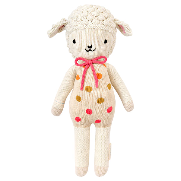 A lamb stuffy in pink polka dot overalls 