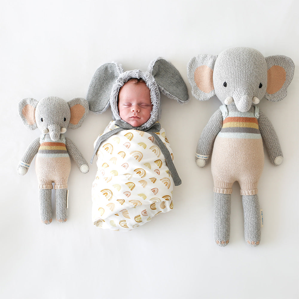 2 different sized elephants on either side of a baby