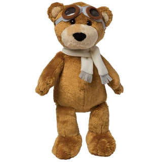 A brown, plush bear is wearing a cream scarf and aviator goggles