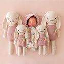 2 big and 2 small bunny stuffies on either side of a sleeping baby