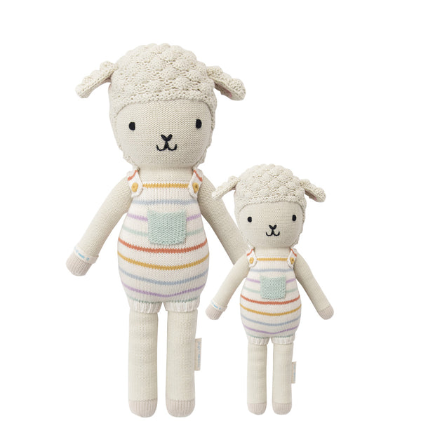 A fabric lamb doll with rainbow striped overalls standing next to a smaller version of the same doll