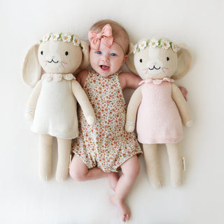 2 bunny stuffies on either side of a baby